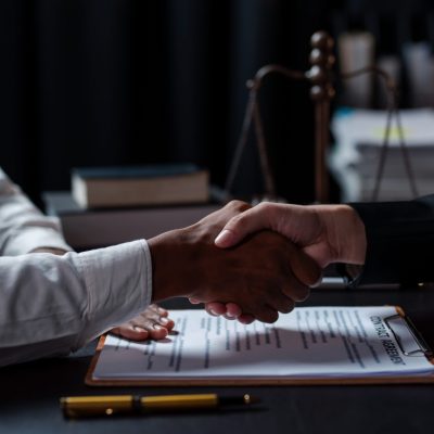 Businessman handshake to seal a deal with his partner lawyers or attorneys discussing a contract agreement.
